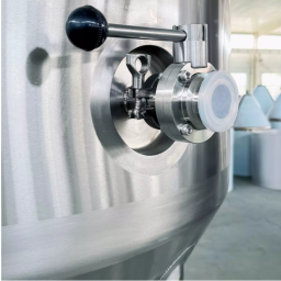 Stainless steel tank with a valve and pressure gauge for liquid processing.