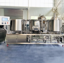 Industrial brewing equipment with stainless steel tanks and a control panel.